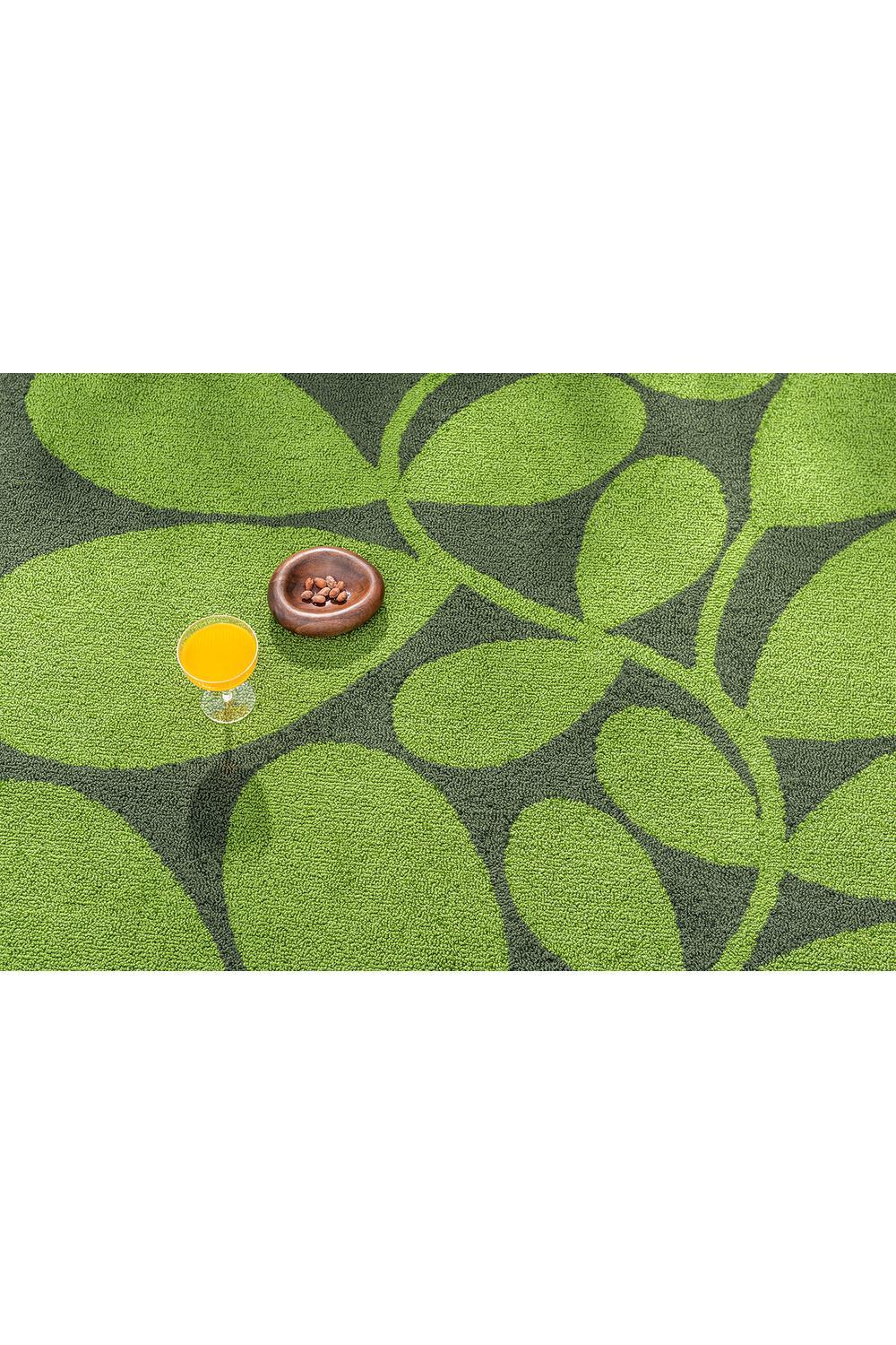 Orla Kiely Sycamore Dill Outdoor Rug featuring leaf pattern in lime green, bright green and dark green on charcoal background, machine-made polypropylene