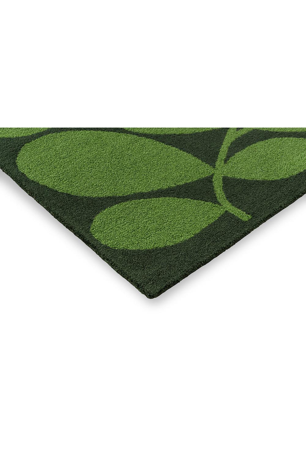 Orla Kiely Sycamore Dill Outdoor Rug featuring leaf pattern in lime green and dark greens on dark green background, machine-made polypropylene