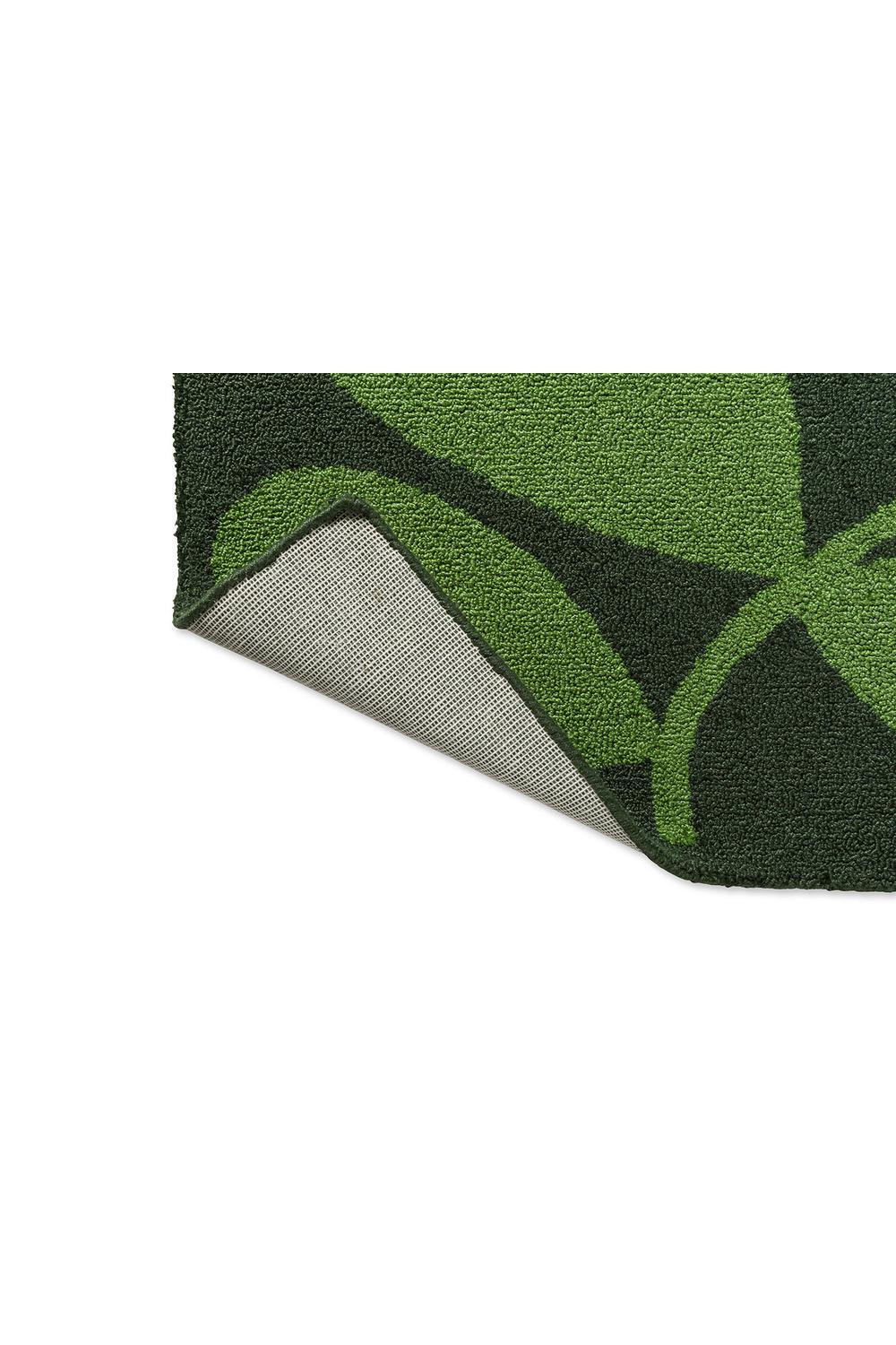 Orla Kiely Sycamore Dill outdoor rug with leafy geometric pattern in lime and forest greens on dark background, loop-pile synthetic fiber