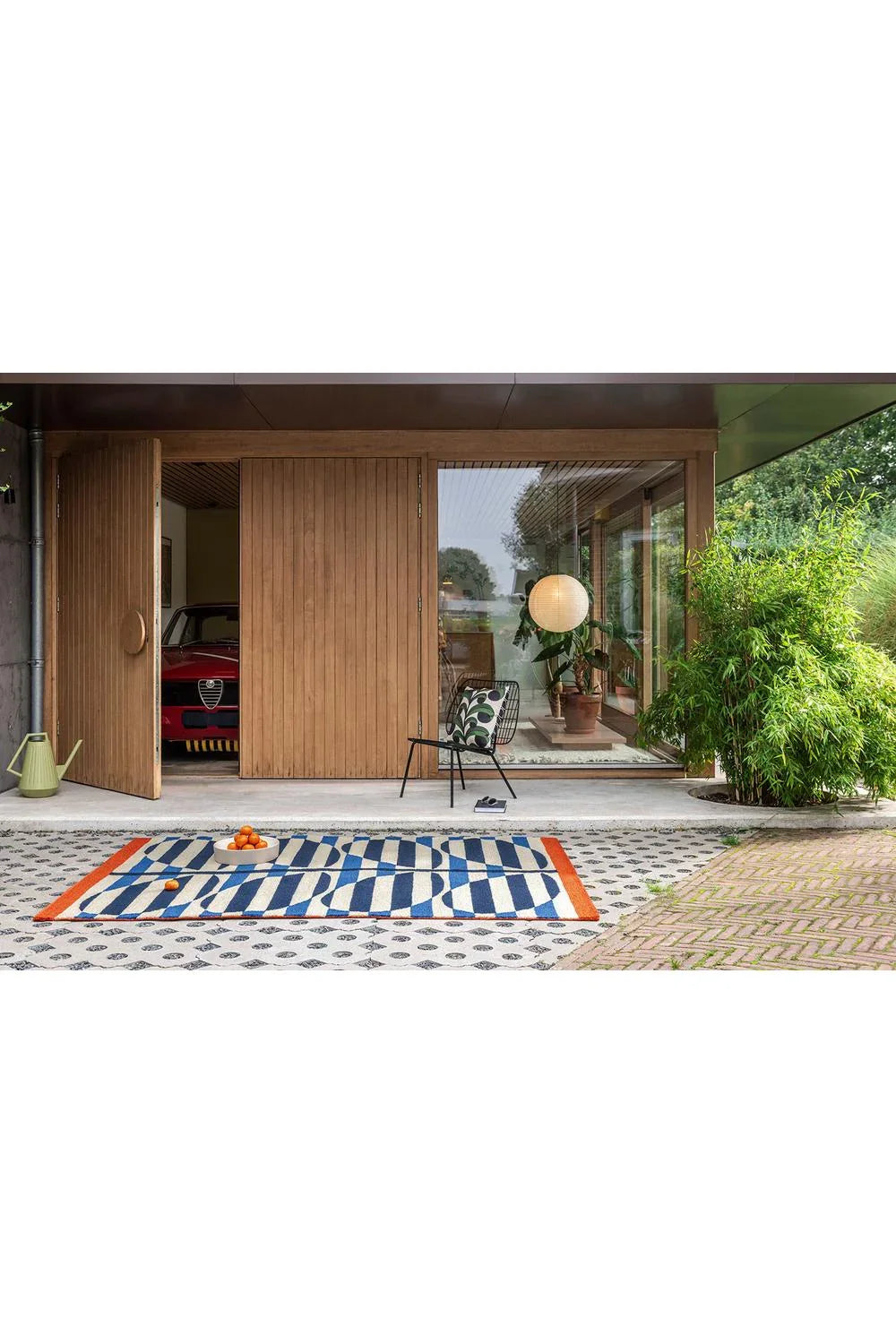 Orla Kiely Stripy Stem Azure outdoor rug featuring bold blue and white stripes with orange border, machine-woven polypropylene