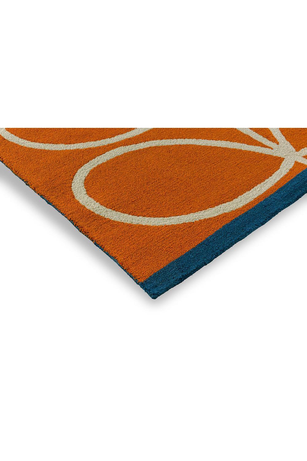 Orla Kiely Linear Stem Orange Outdoor Rug featuring curved cream lines on orange field with teal edge, power-loomed polypropylene