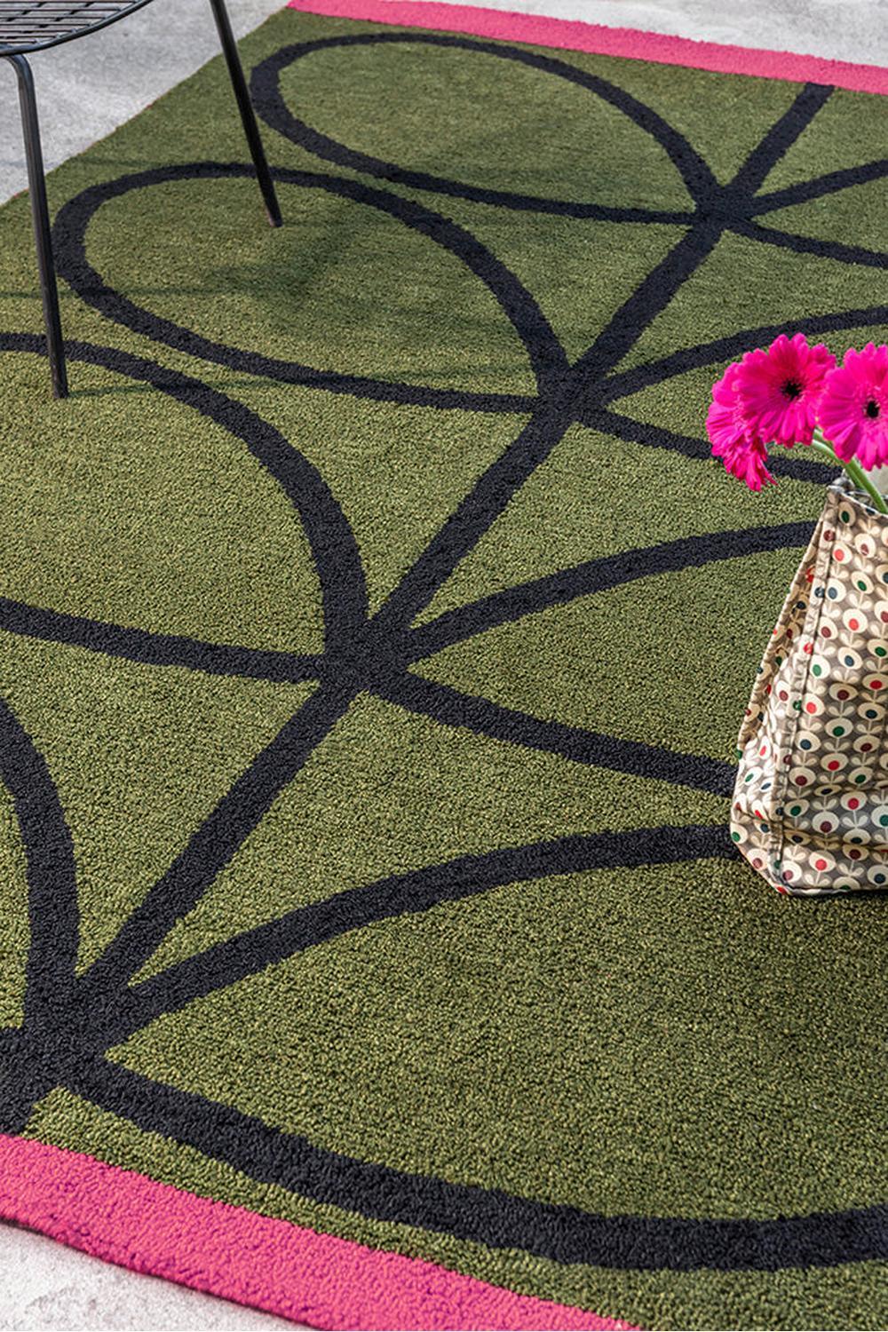 Orla Kiely Linear Stem Olive Outdoor Rug featuring circular geometric pattern in olive green, black and pink on light border, power-loomed polypropylene