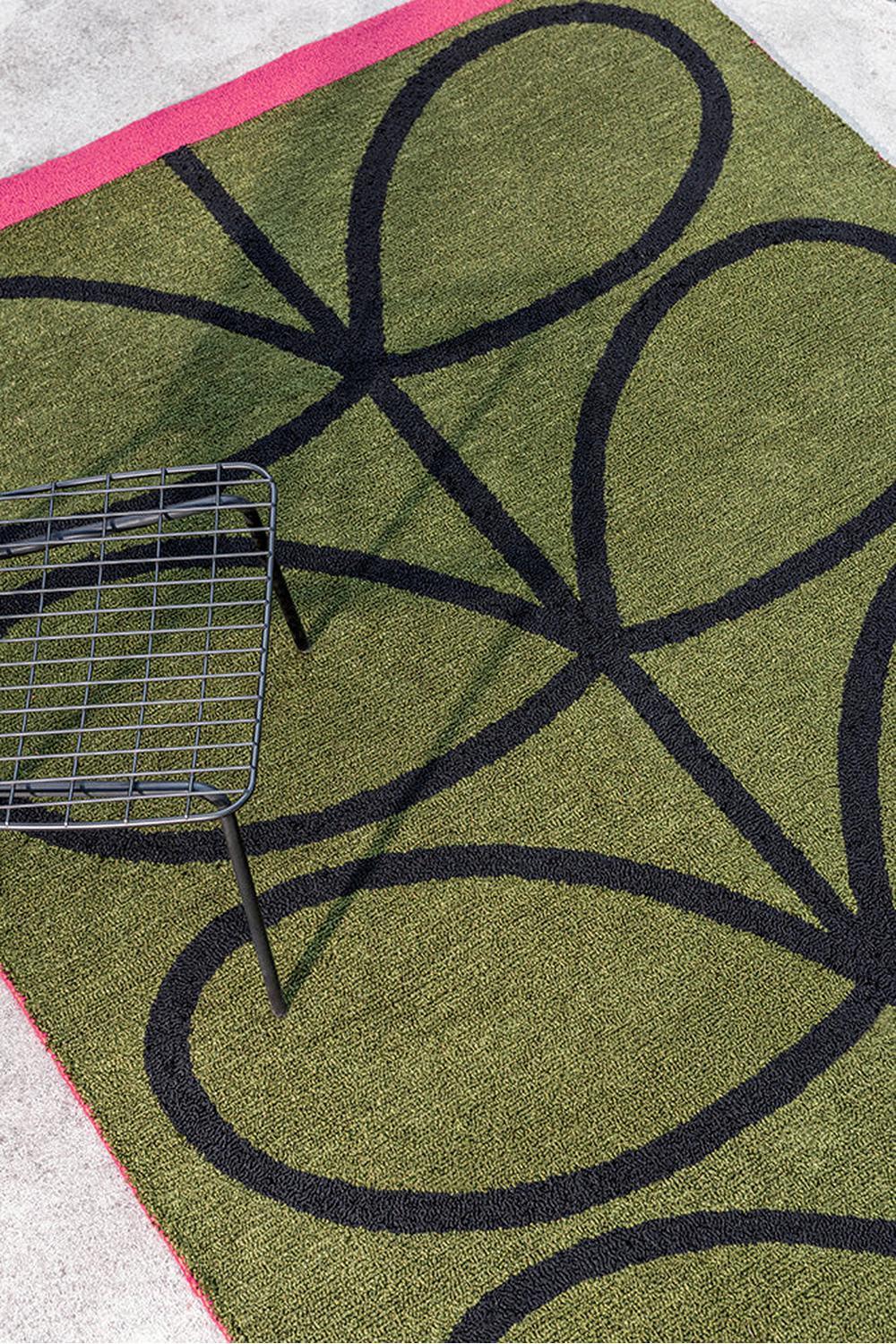 Orla Kiely Linear Stem Olive Outdoor Rug with bold botanical pattern in olive green, black and pink on light grey background, power-loomed polypropylene