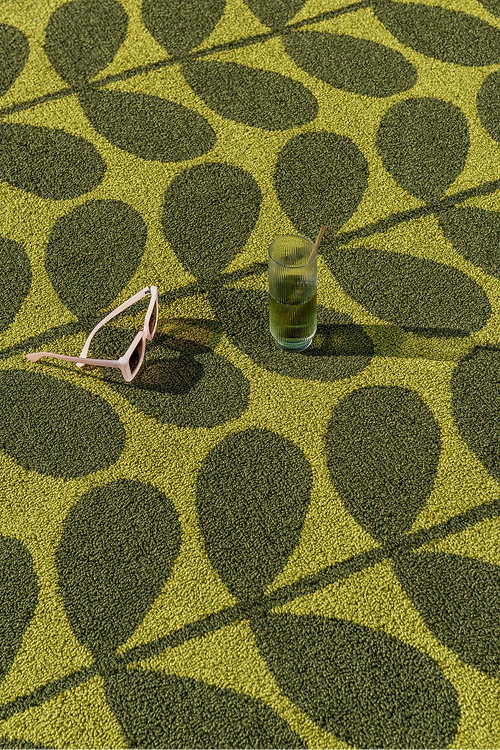 Orla Kiely Solid Stem Seagrass outdoor rug featuring leaf pattern in lime yellow and olive green on pale yellow background, handwoven seagrass