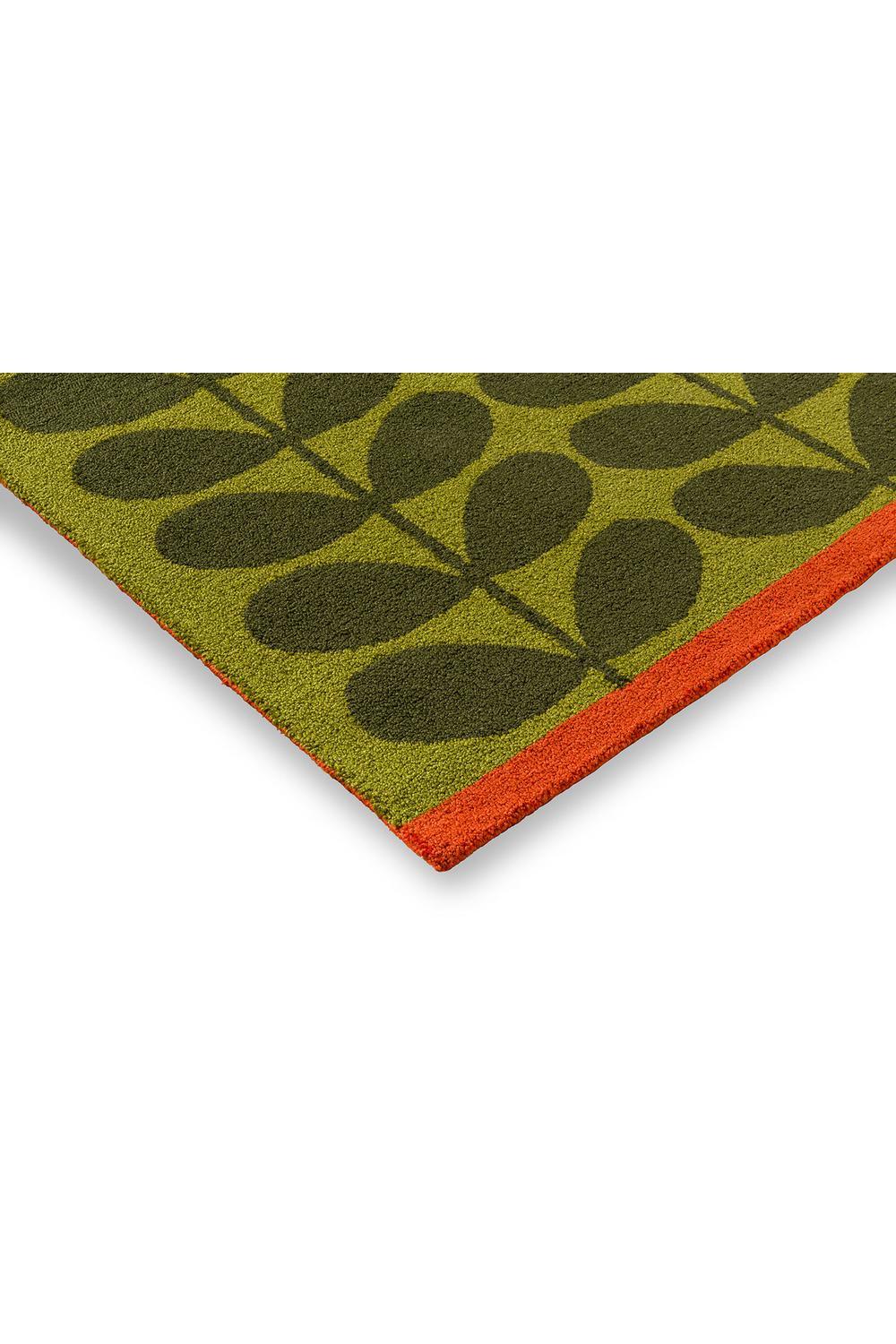 Orla Kiely Solid Stem Seagrass Outdoor Rug featuring botanical leaf pattern in olive green, dark green and orange on olive background, hand-woven seagrass