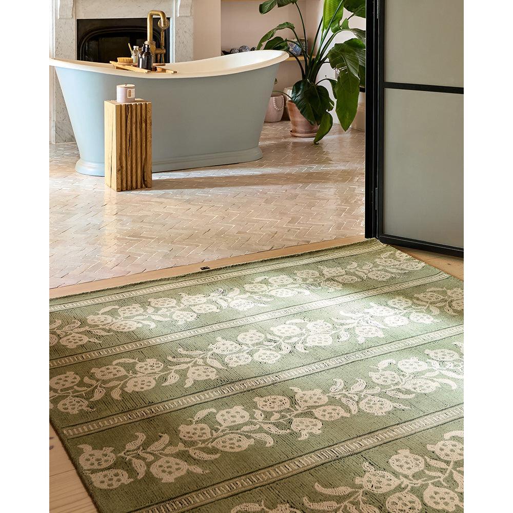 Sanderson Anaar Forest Green Rug featuring botanical floral pattern in forest green and white on beige background, hand-tufted wool