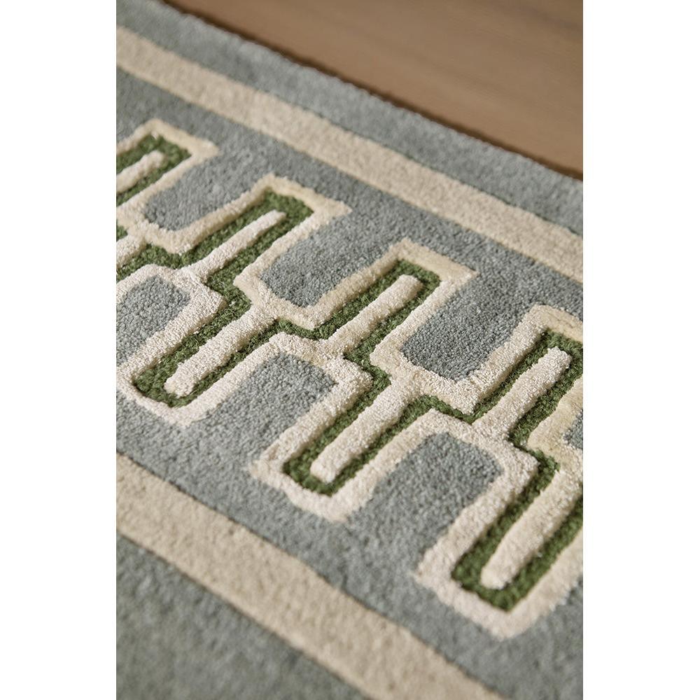 Sanderson Linnean Porcelain designer rug featuring Greek-key geometric pattern in cream, sage-green and olive on blue-grey background, hand-tufted wool