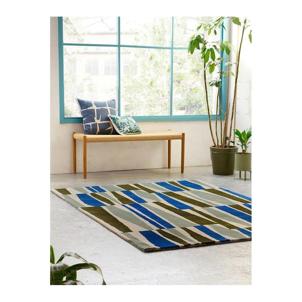Scion Saku olive rug featuring bold striped pattern in olive, royal blue, beige on cream background, hand-tufted wool