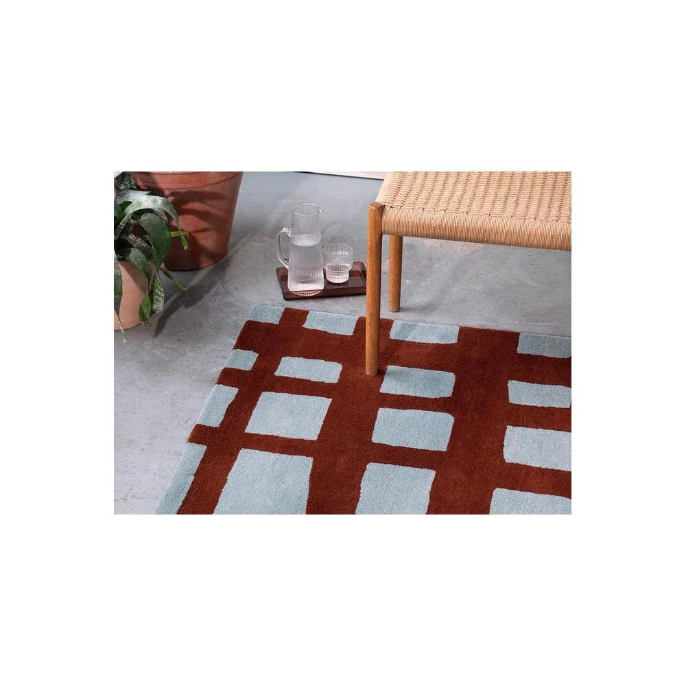Scion Arlo brick rug featuring geometric grid in brick red and light blue on pale gray background, hand-tufted wool
