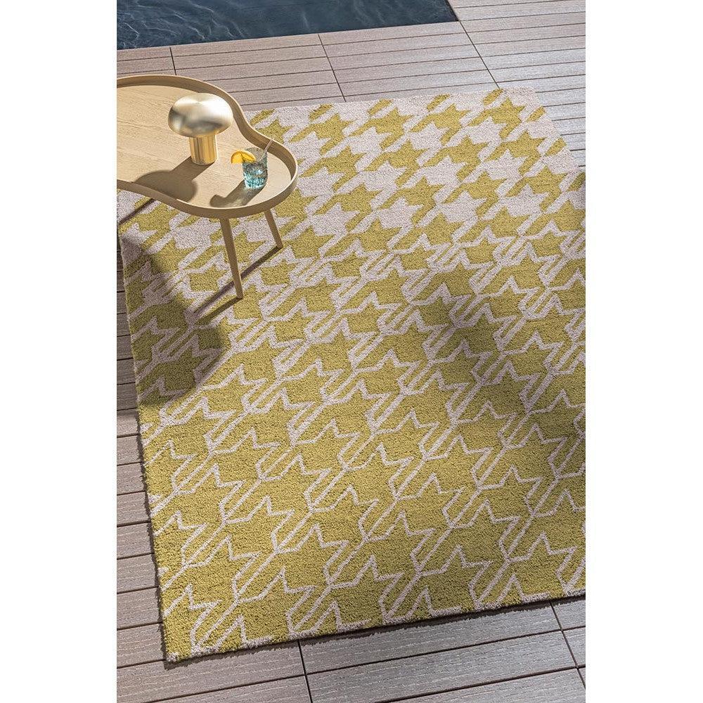 Ted Baker Houndstooth Mustard Outdoor Rug featuring mustard and cream houndstooth on tan wooden deck, power-loomed polypropylene