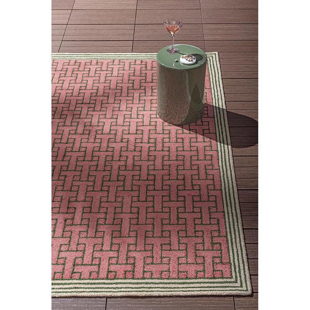 Ted Baker T Monogram Dusted Pink Outdoor Rug featuring T-pattern in dusty pink, rose pink, cream with sage border on brown deck, machine-woven polypropylene