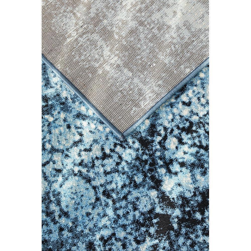 Calypso Navy Rug featuring abstract mottled pattern in navy, cobalt and light blue on deep blue background, machine-made wool blend