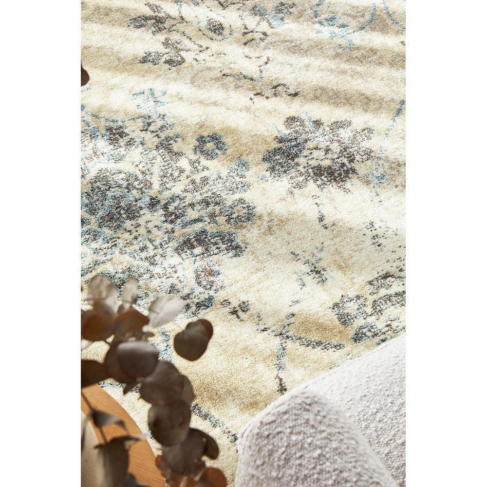 Calypso Bone Rug featuring floral motif in ivory, dusty blue and charcoal on beige background, machine-loomed polypropylene