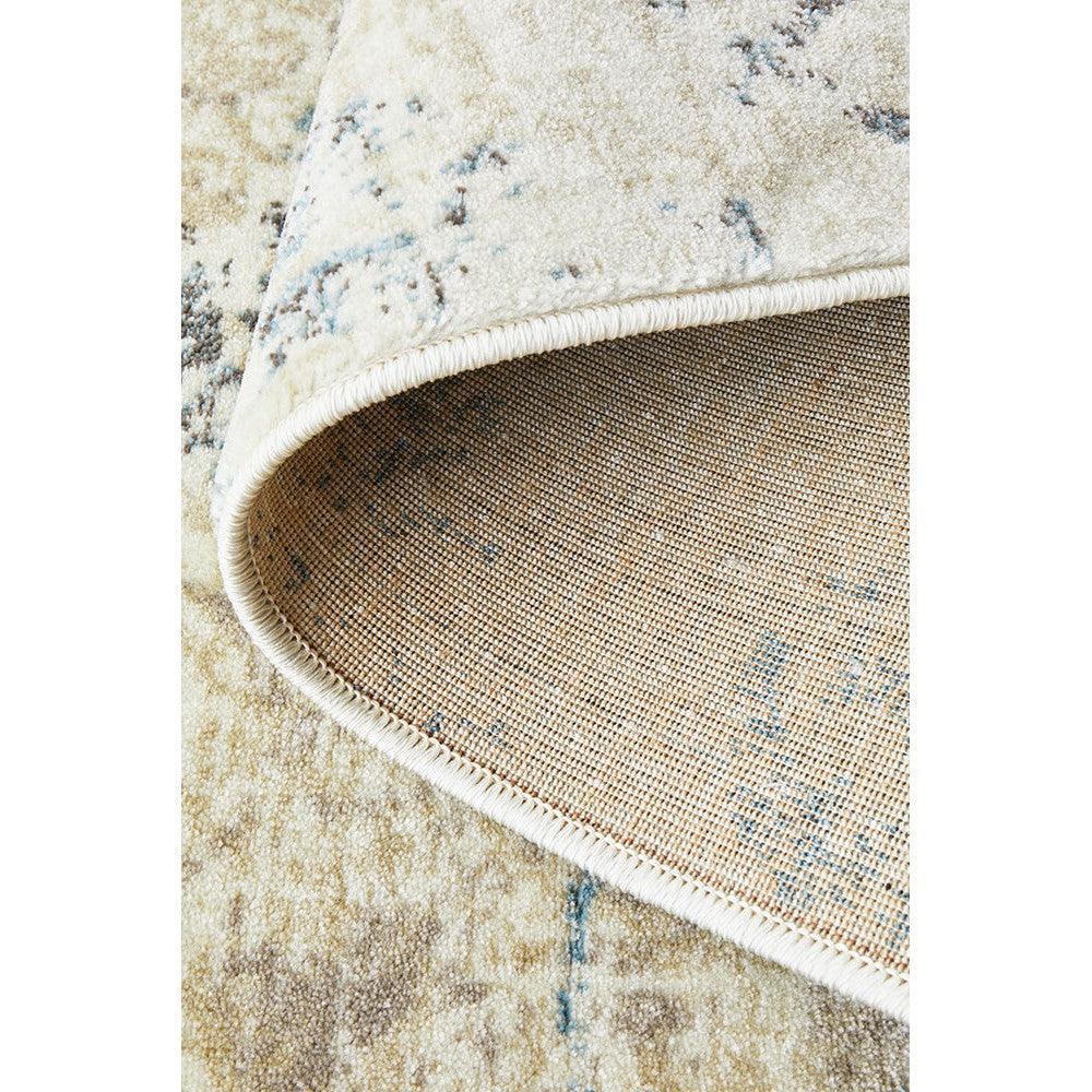 Calypso Bone Rug featuring distressed abstract pattern in ivory, bone and pale blue on warm beige background, hand-tufted wool