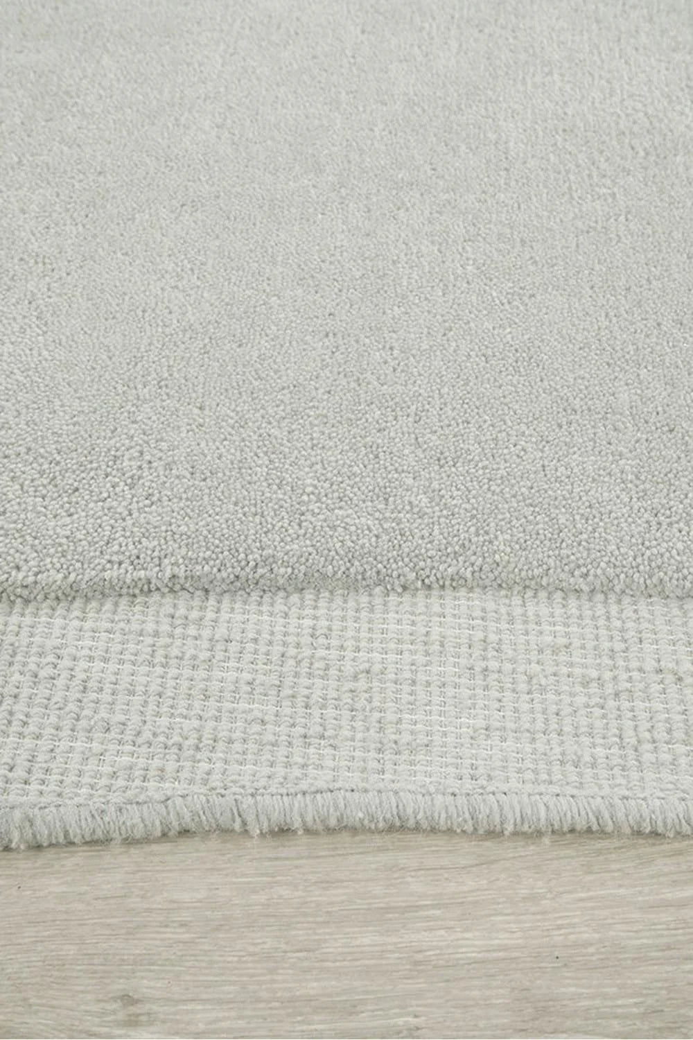 Cleo Dove Rug featuring solid textured looped pile in dove grey with ivory undertones on soft beige background, hand-tufted wool