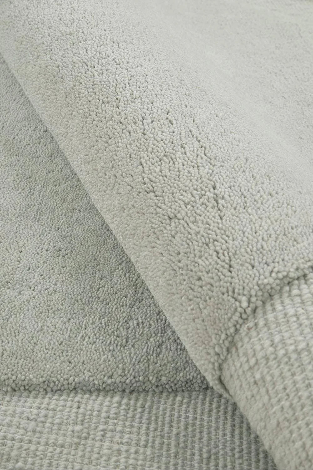 Cleo Dove Rug featuring plush boucle texture in dove grey, light grey and charcoal on soft light-grey background, hand-tufted wool