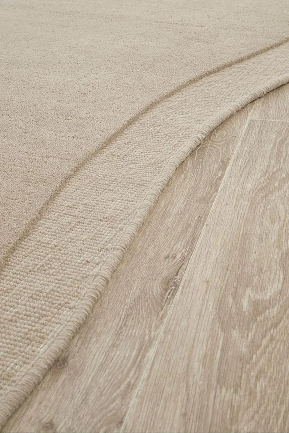 Cleo Latte Rug featuring soft textured solid design in beige latte and cream on warm beige background, hand-tufted wool