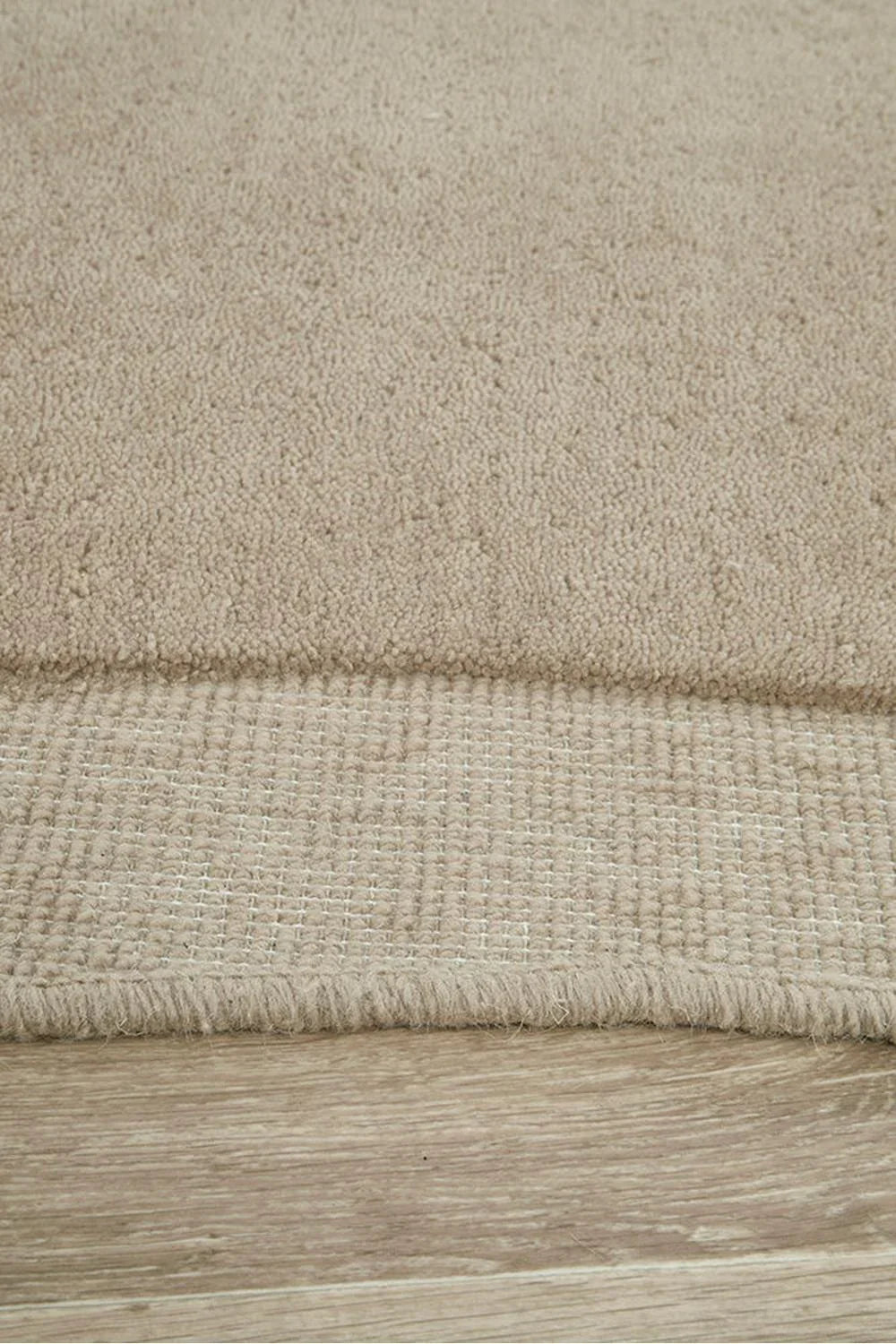 Cleo Latte Rug featuring solid plush texture in latte beige on light wood floor, woven wool