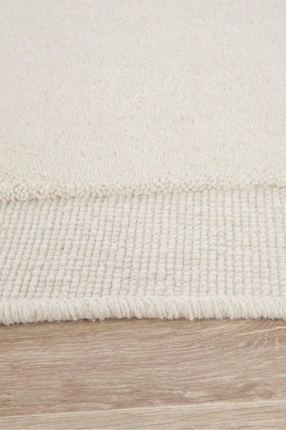 Cleo Milk Rug featuring plush boucle pile in ivory cream on light wood floor, hand-tufted wool