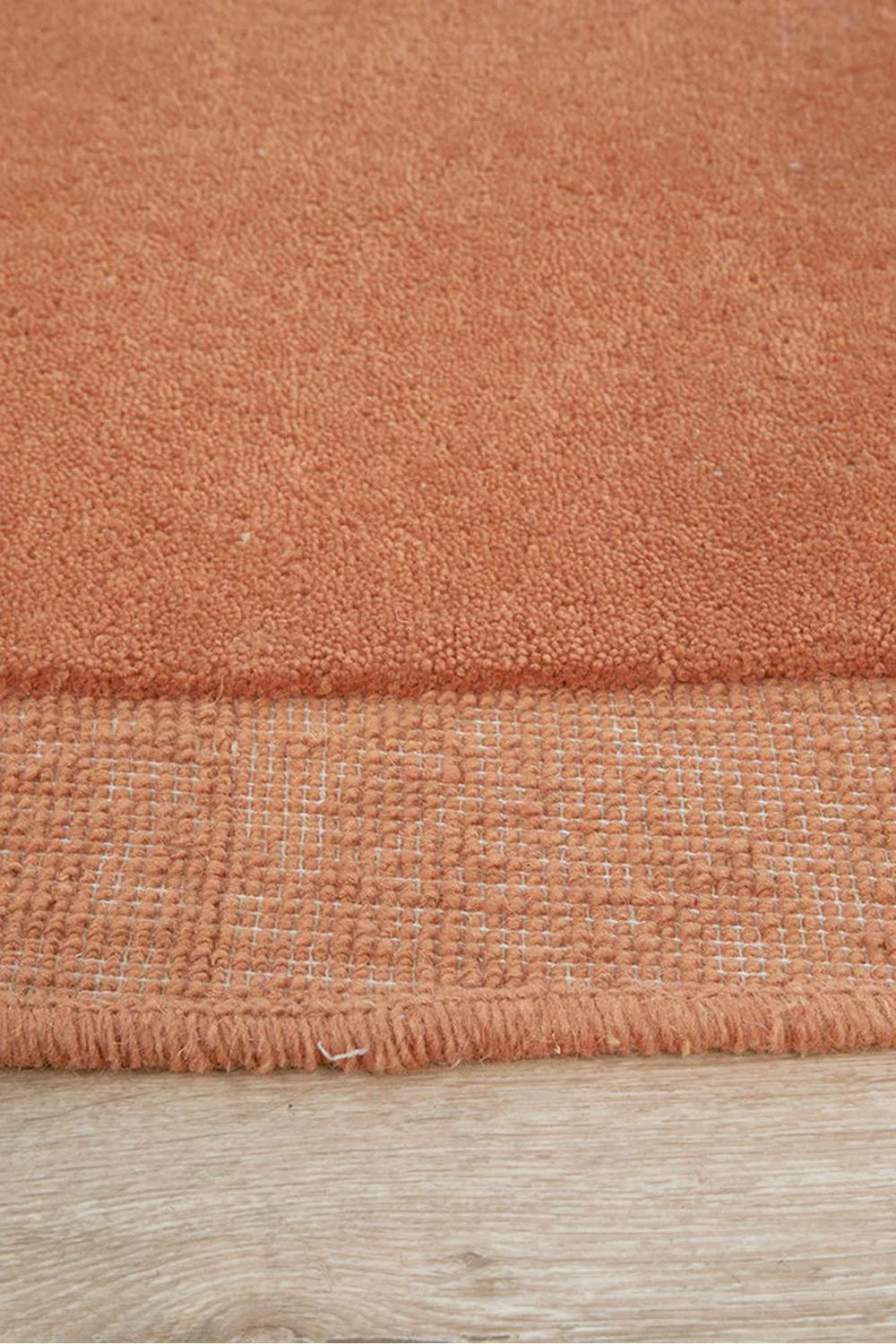 Cleo Spice Rug featuring textured solid loop design in terracotta, burnt orange & cream on warm terracotta background, hand-tufted wool