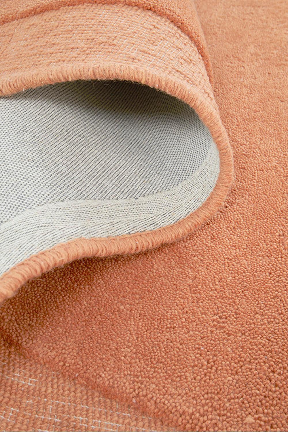 Cleo Spice Rug featuring soft curved pattern in warm terracotta, coral and peach on light grey backing, hand-tufted wool