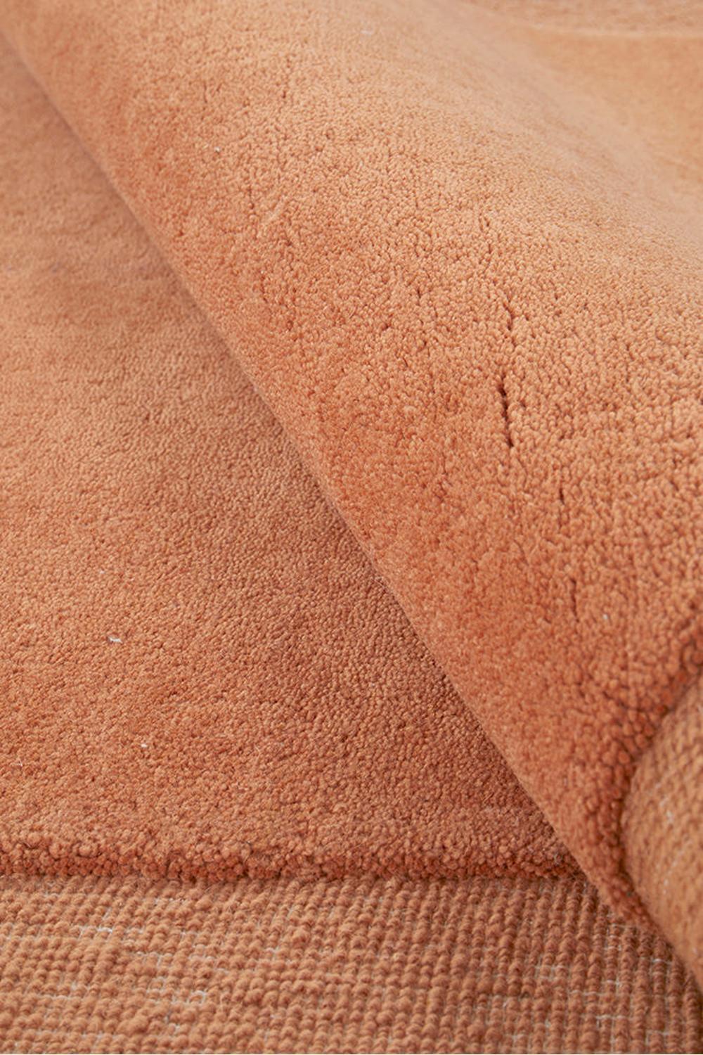 Cleo Spice Rug featuring solid plush pile in terracotta orange on warm terracotta background, hand-tufted wool