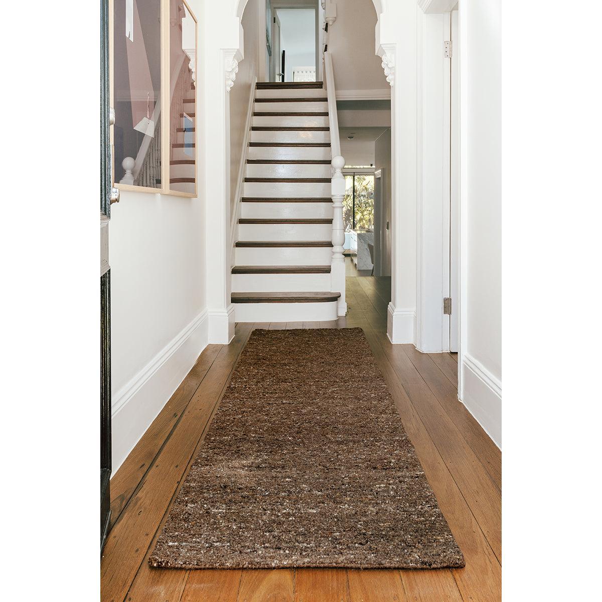Conscious Loom Embrace Brown Runner Rug with speckled pattern in coffee brown, tan & cream on wood floor tufted wool