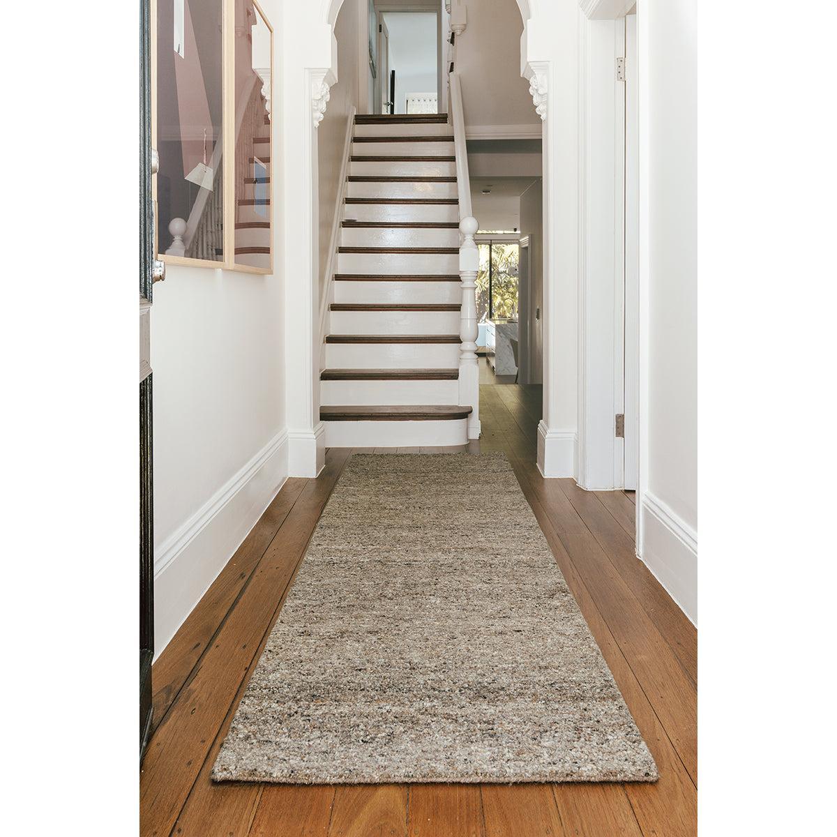 Conscious Loom Embrace Stone Runner Rug featuring speckled beige taupe and cream on brown wood floor hand-woven wool