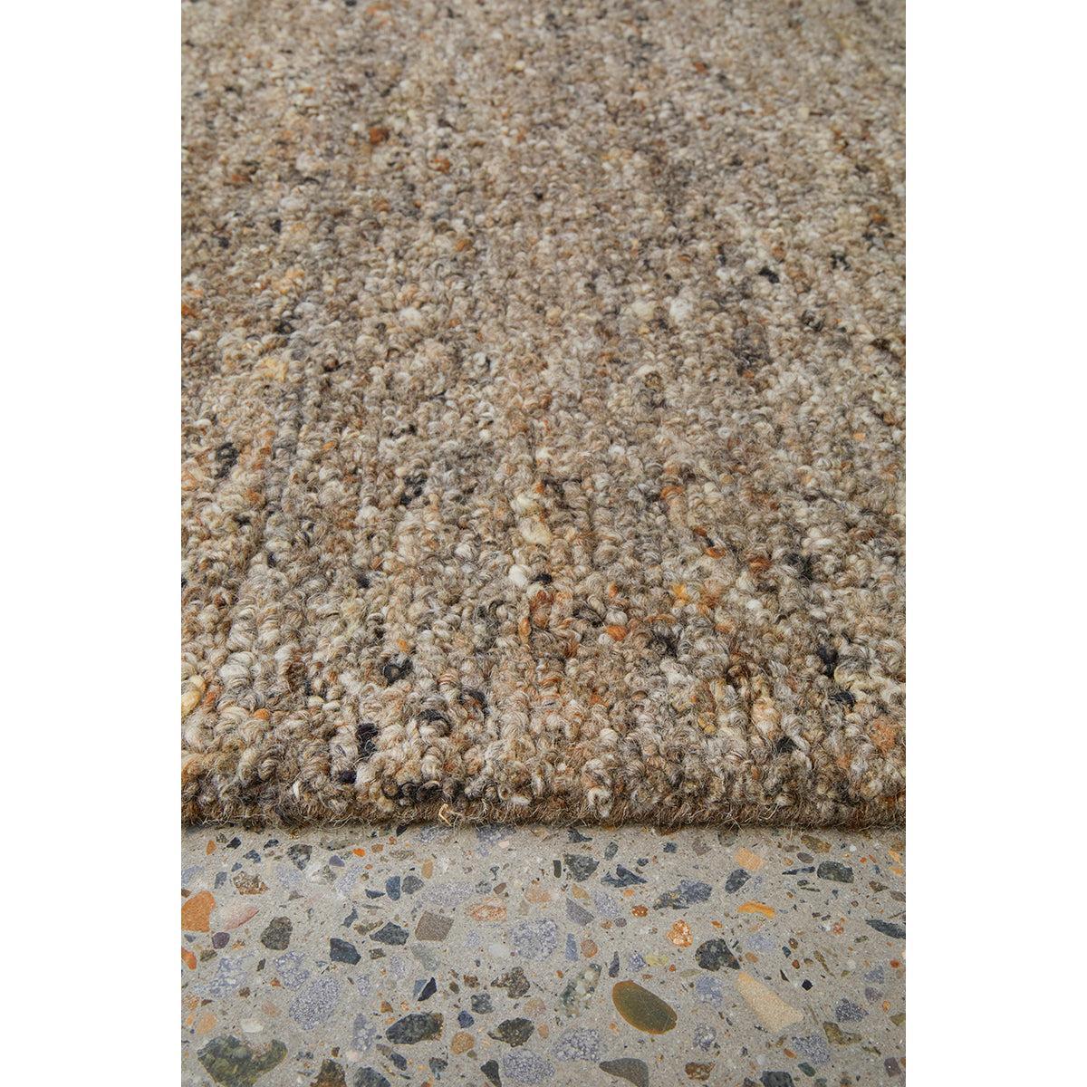 Conscious Loom Embrace Stone Rug featuring textured shag in stone, taupe, cream on light grey terrazzo, hand-tufted wool