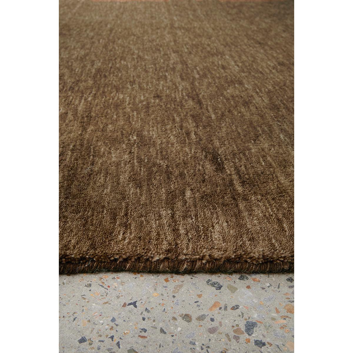 Conscious Loom Kinship Bear Brown Runner Rug featuring textured solid pattern in dark chocolate and medium brown on light grey terrazzo, hand-tufted wool