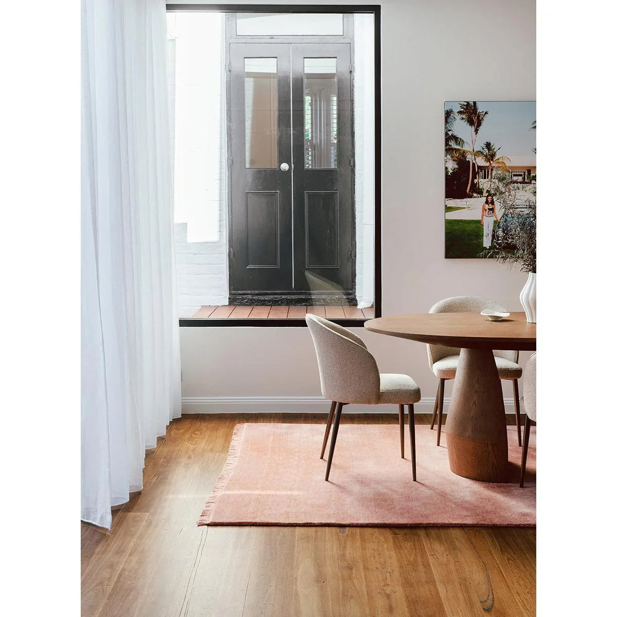 Conscious Loom Kinship rug featuring solid blush-pink with peach and rose pink undertones on brown floor, woven wool