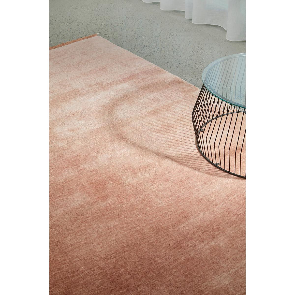 Conscious Loom Kinship Blush Pink Rug featuring solid blush-pink tone with peach and dusty rose on grey floor, hand-tufted wool