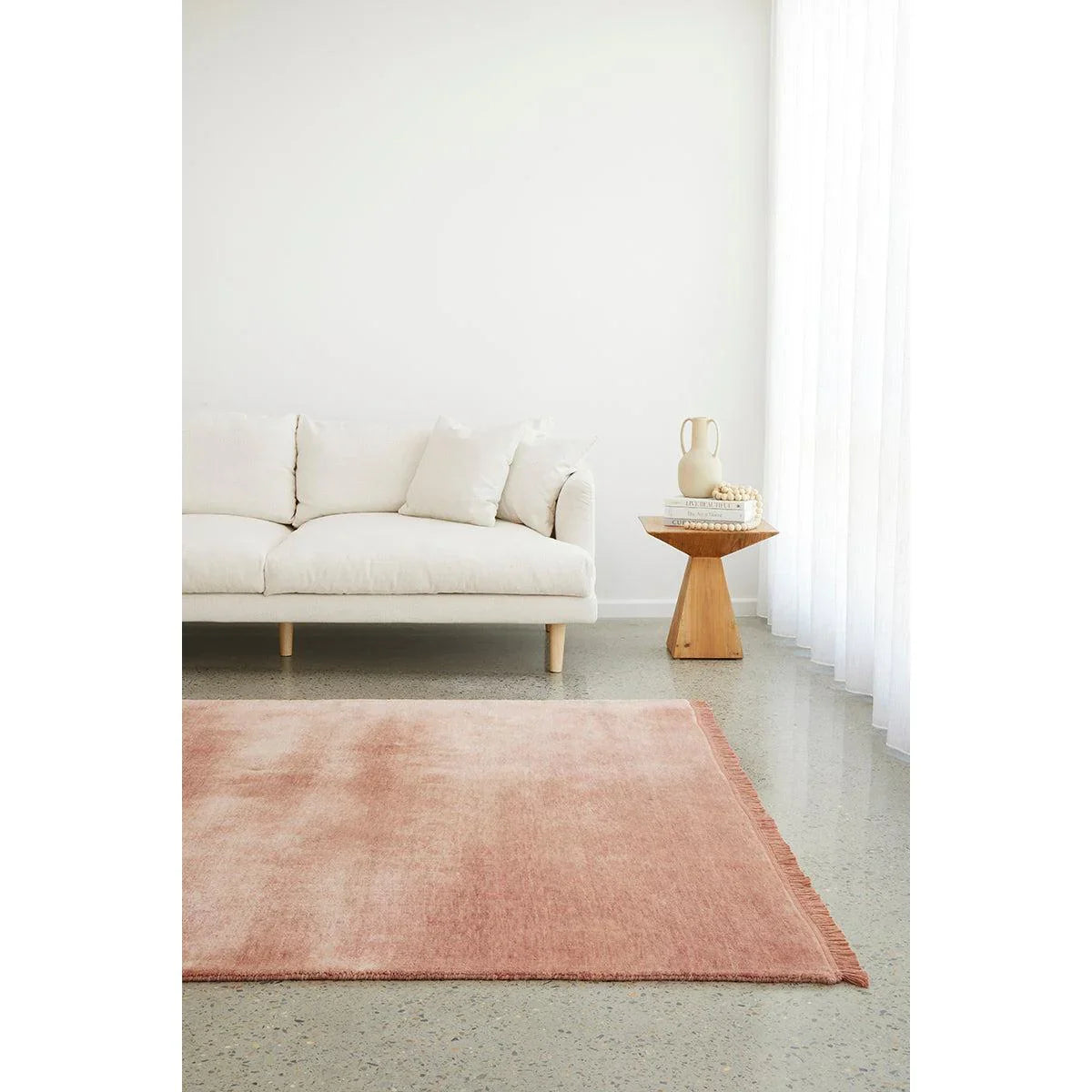 Conscious Loom Kinship Blush Pink Rug featuring solid colour in blush pink, white and cream on grey floor, tufted wool