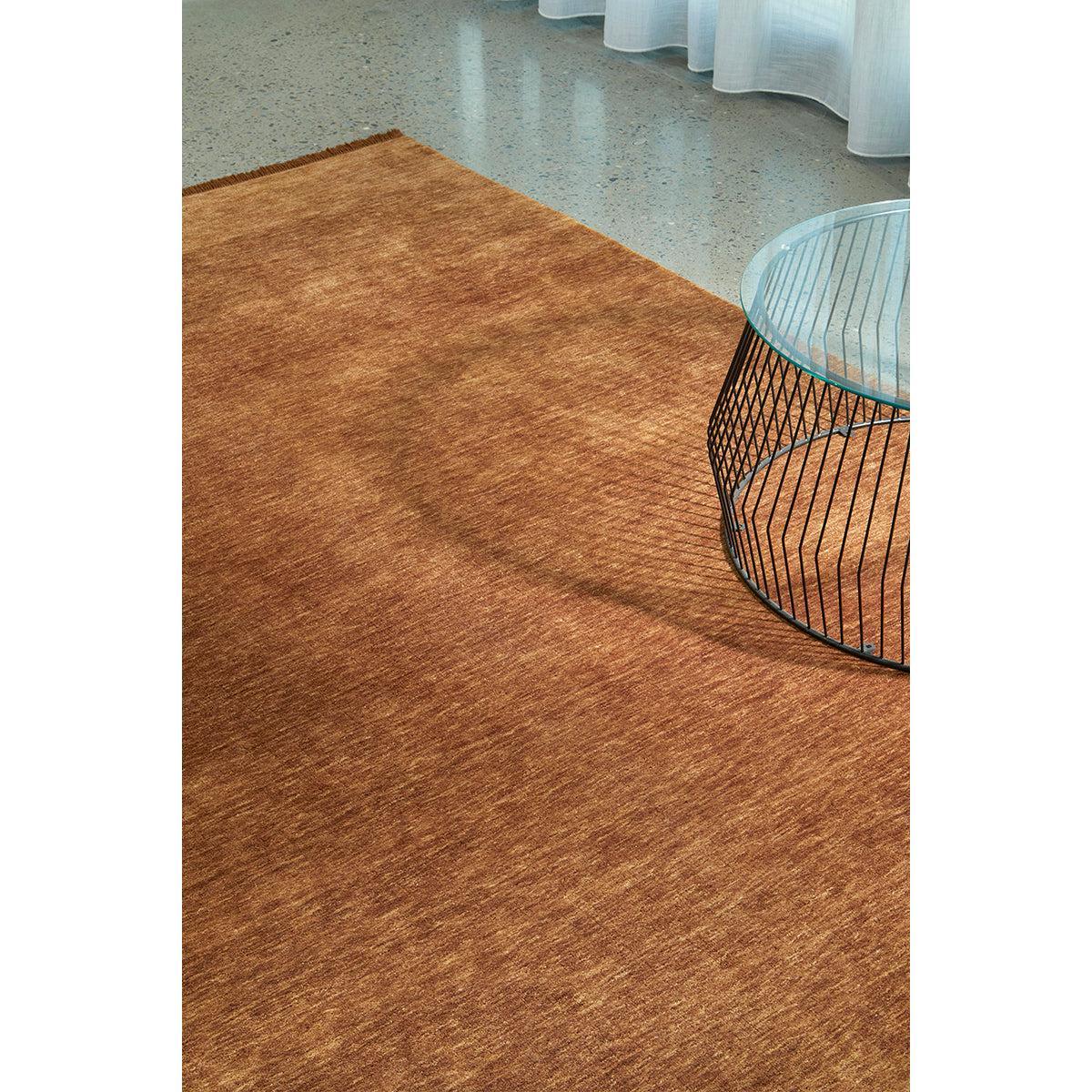 Conscious Loom Kinship Caramel Rug featuring textured design in caramel and copper on light grey floor, loom-woven wool