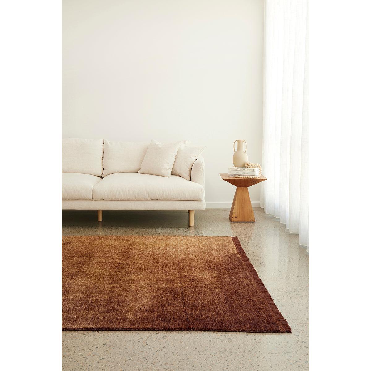 Conscious Loom Kinship Caramel Rug featuring textured weave in caramel, rust and copper on beige floor, hand-tufted wool