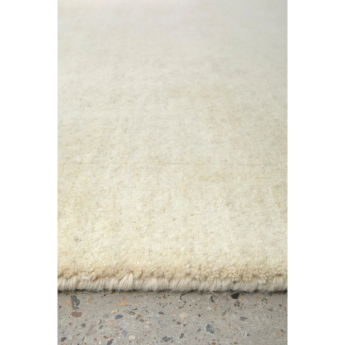 Conscious Loom Kinship Cream Runner Rug featuring solid shag in cream, ivory on light grey concrete, power-loomed wool