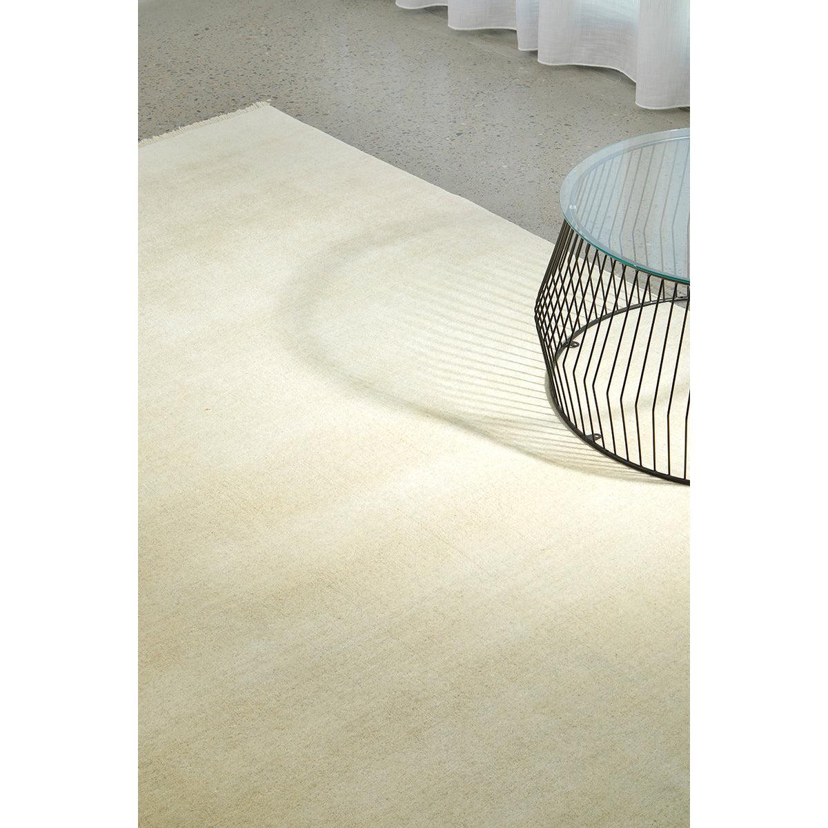 Conscious Loom Kinship Cream Rug featuring solid-textured cream, ivory and beige on pale grey floor, hand-loomed wool