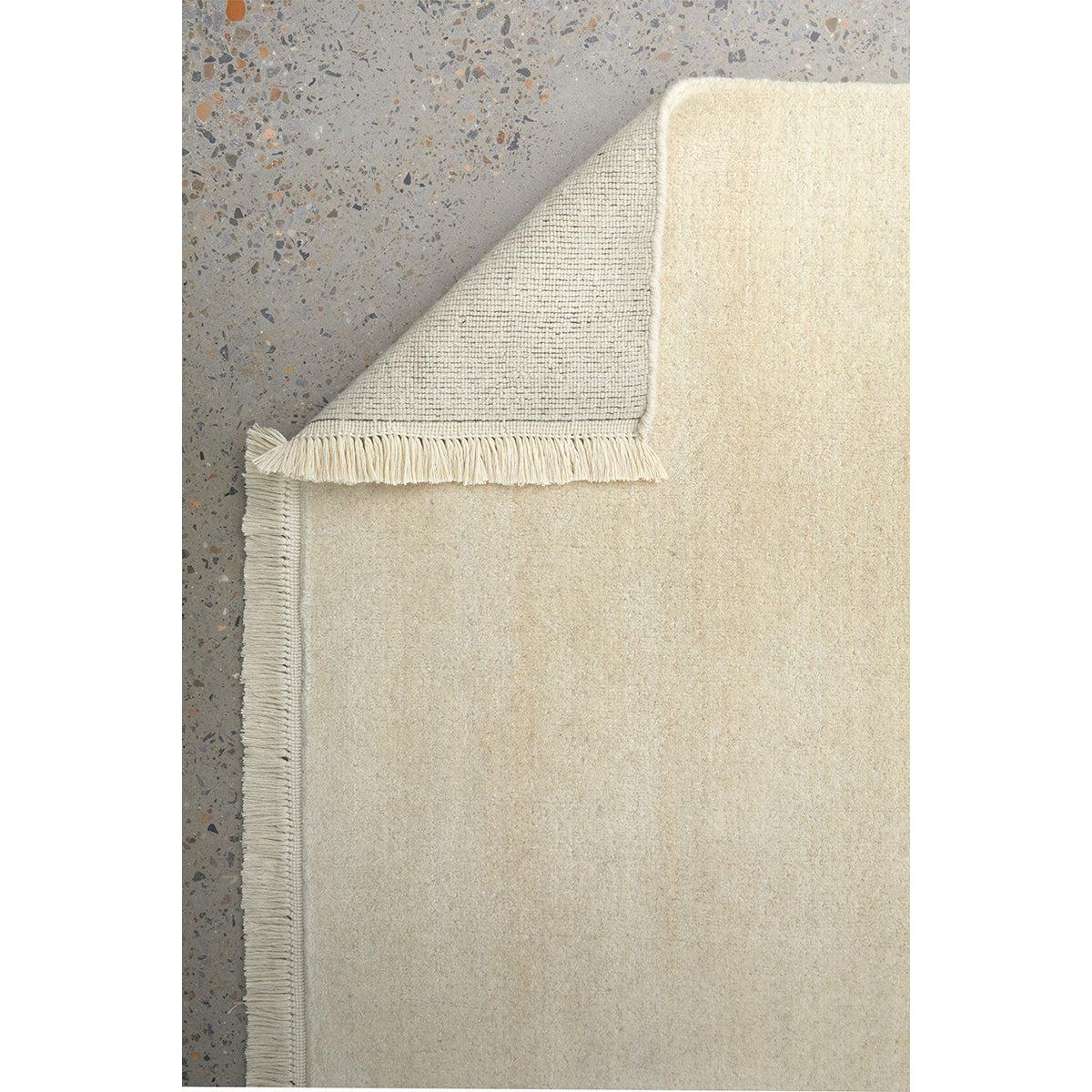 Conscious Loom Kinship Cream Rug featuring solid field in cream, ivory and light grey on grey background, tufted wool