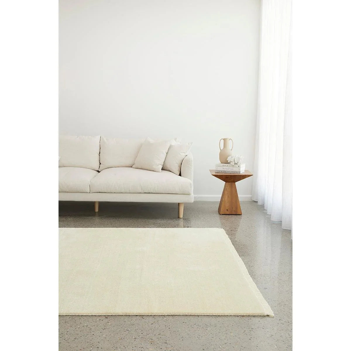 Conscious Loom Kinship Cream Rug featuring solid-colour in cream, ivory and beige on light grey floor, hand-woven wool