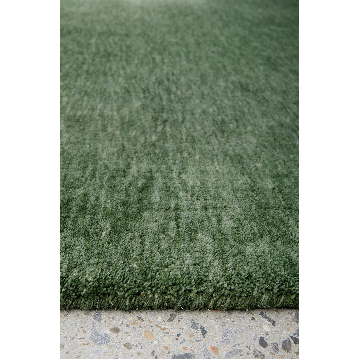 Conscious Loom Kinship Forest Green Runner Rug featuring solid textured forest green pile on light grey background