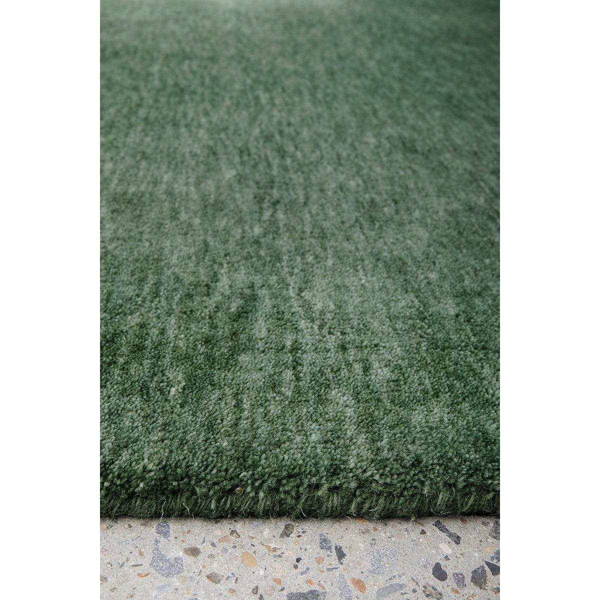 Conscious Loom Kinship Forest Green Rug featuring shaggy texture in forest green on grey terrazzo, hand-tufted wool
