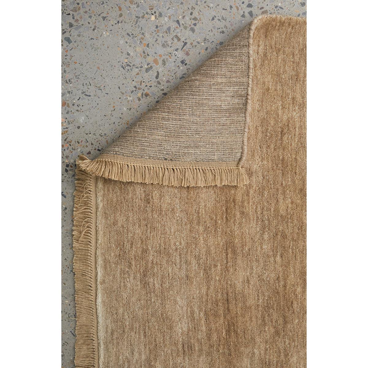 Conscious Loom Kinship Oyster Rug featuring solid-textured weave in beige, taupe & cream on grey terrazzo handwoven wool