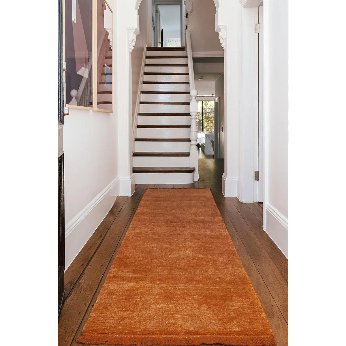 Conscious Loom Kinship Paprika Runner Rug featuring solid paprika orange on white hallway backdrop, hand-tufted wool