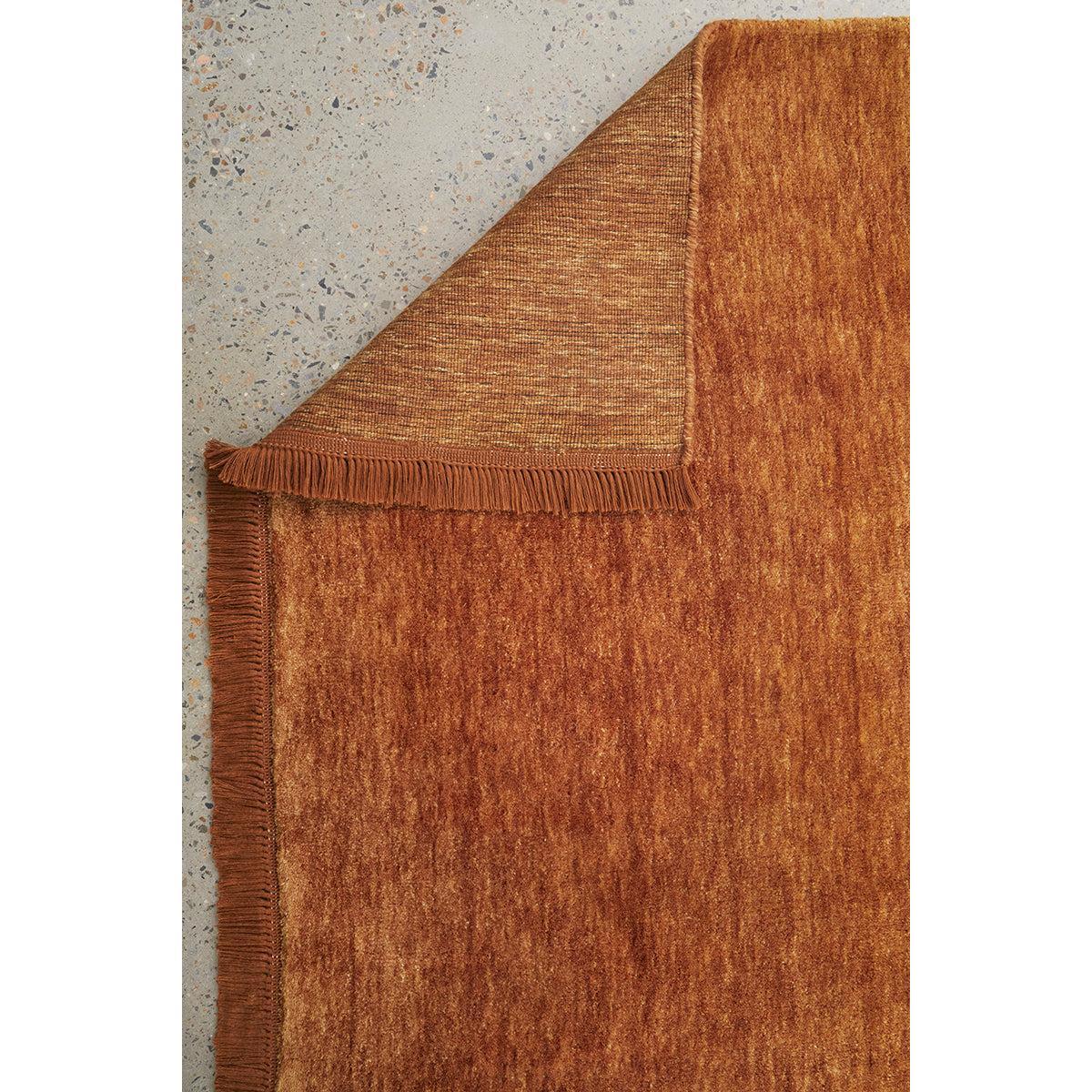 Conscious Loom Kinship Paprika Rug featuring textured paprika orange on light grey terrazzo, tufted wool