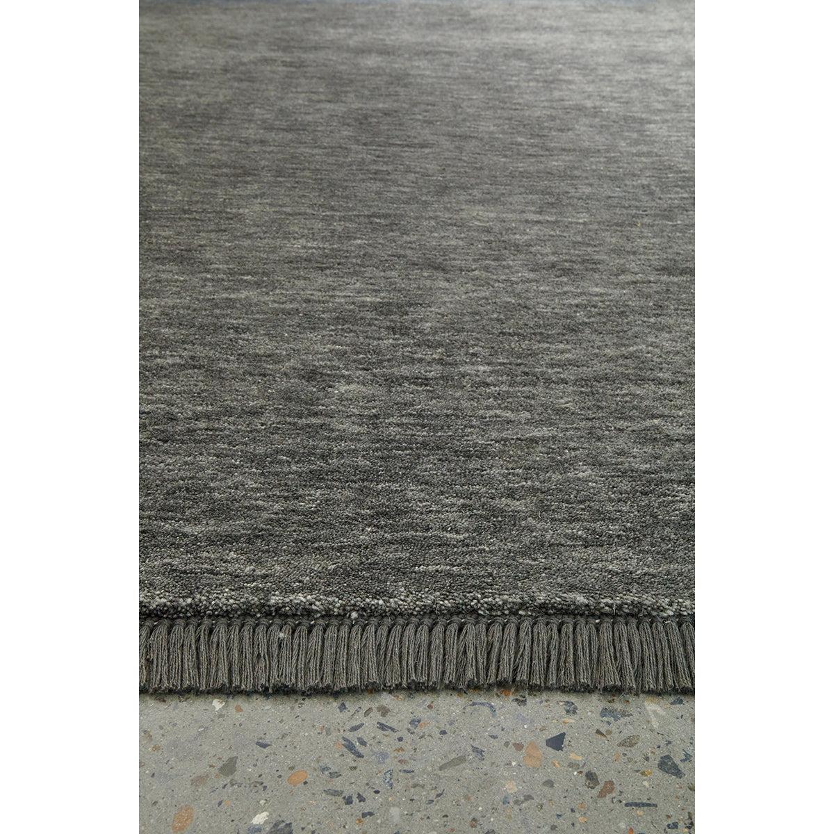 Conscious Loom Kinship Seal Grey Rug featuring solid textured weave in charcoal, slate and grey on concrete, tufted wool