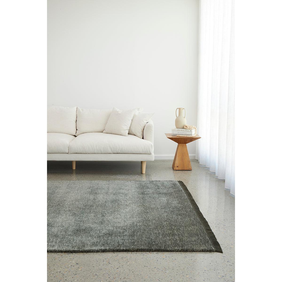 Conscious Loom Kinship Seal Grey Rug featuring gradient in charcoal and slate greys on light-grey floor, handwoven wool