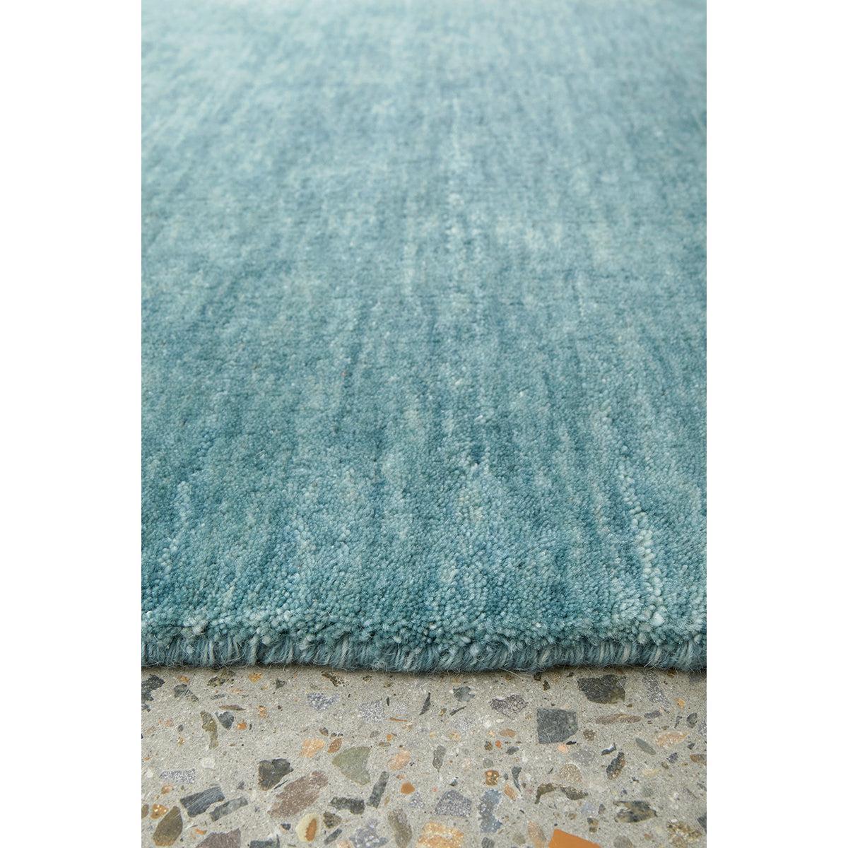 Conscious Loom Kinship Sky Blue Rug by Rug Culture, textured sky-blue on neutral terrazzo floor