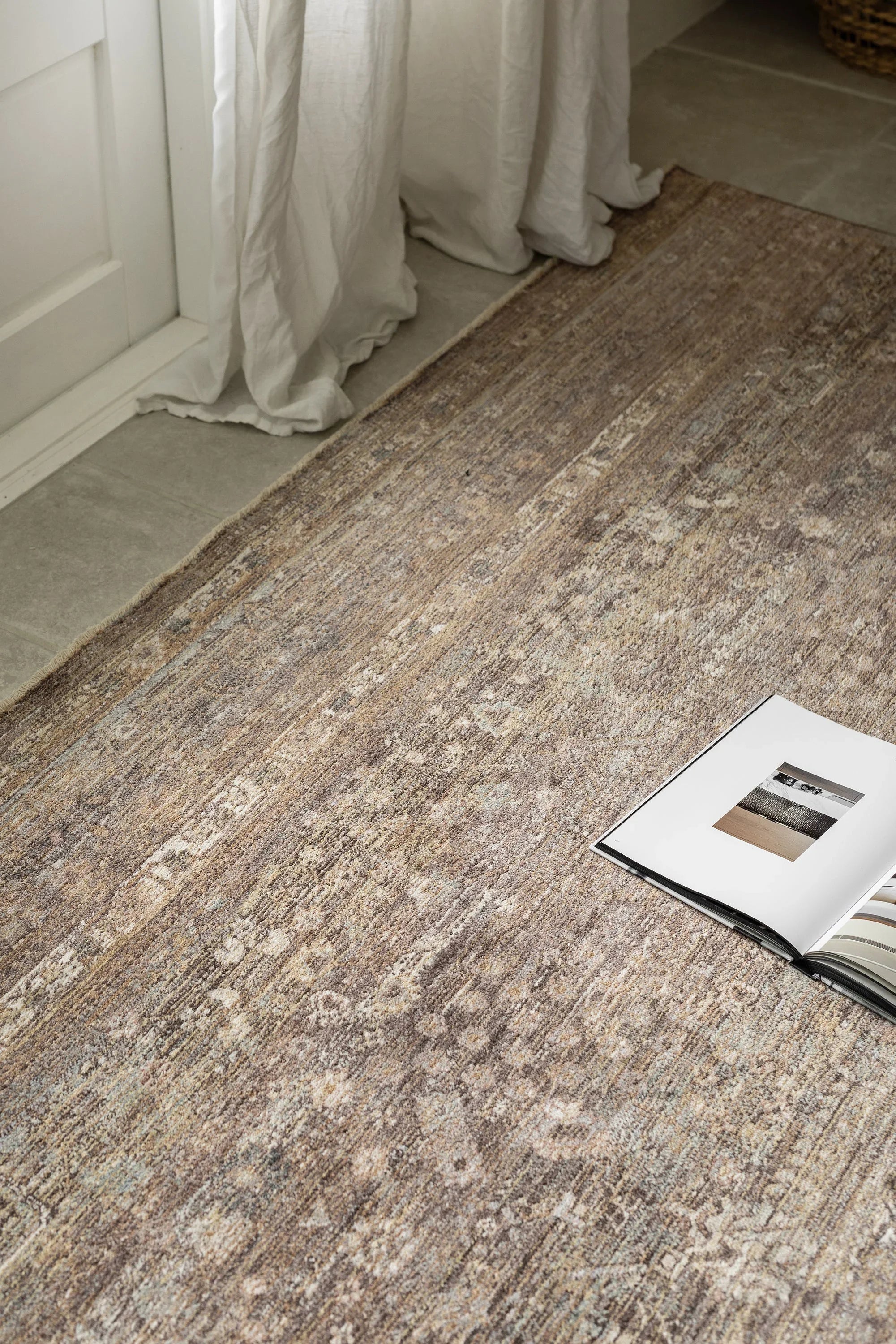 Darren Palmer Moorland Fig Rug distressed pattern in caramel, taupe and ivory on light grey floor, machine-made wool