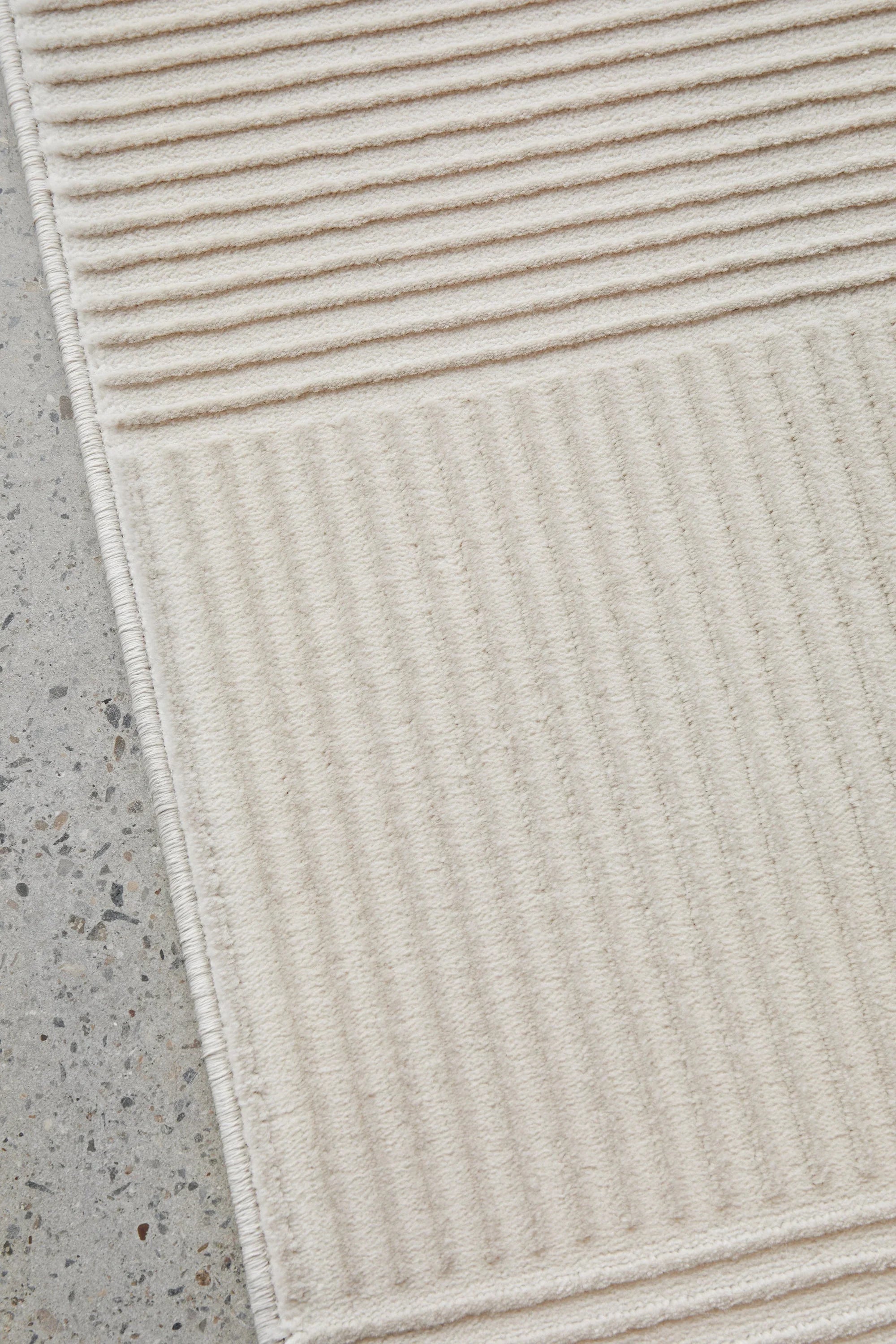 Darren Palmer Raking Linen Rug featuring ribbed texture in cream ivory beige on light grey background hand-tufted linen