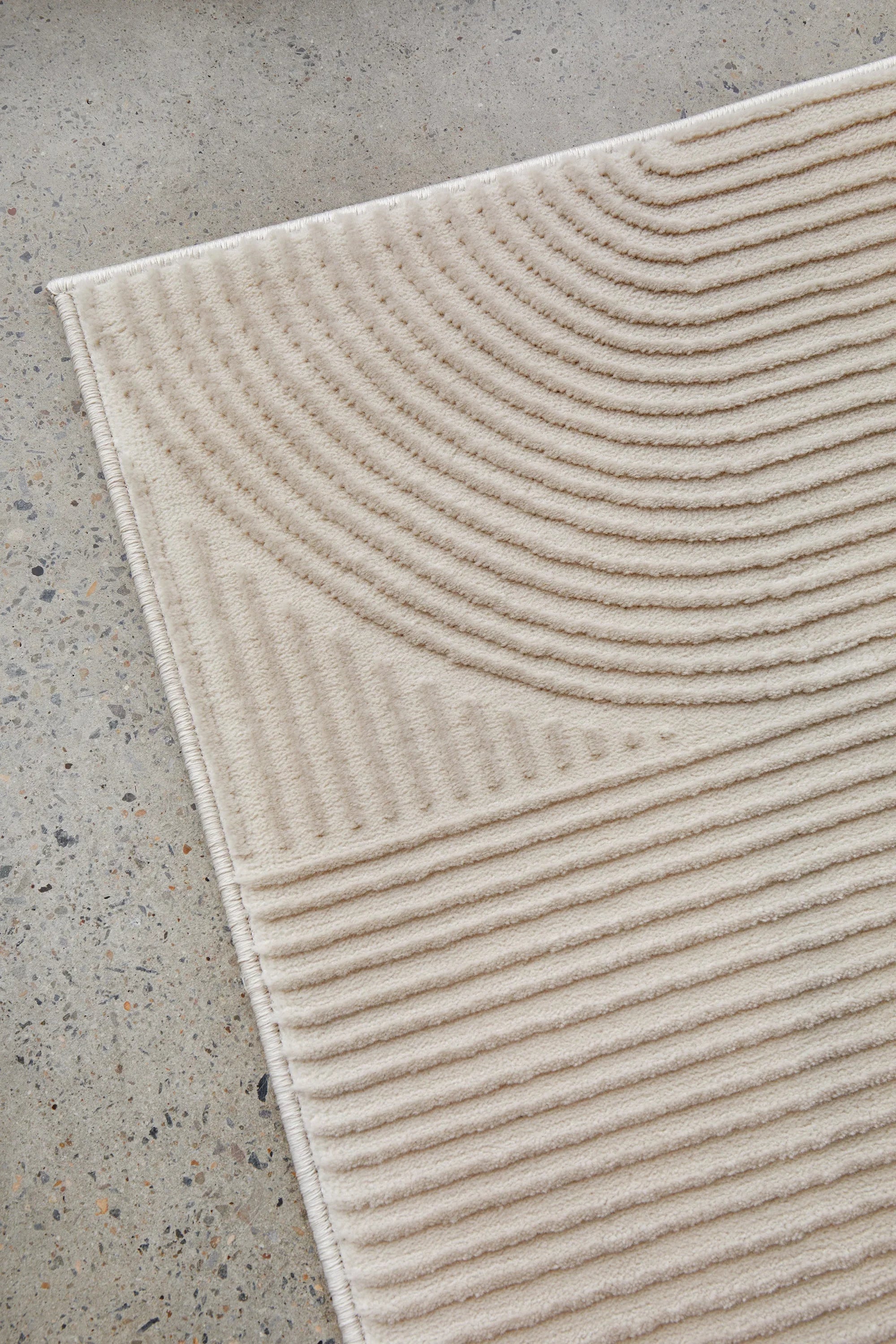 Darren Palmer Raking Linen Rug featuring ribbed pattern in cream and beige on grey background, machine-woven linen